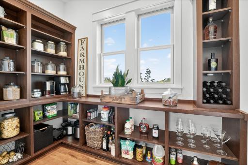 Walk-in pantry with custom wood shelving, wine storage, and plenty of space for organization.