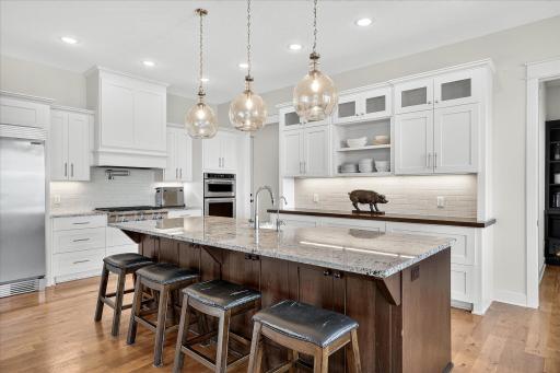 Stunning chefâs kitchen with a large center island, granite countertops, and stylish pendant lighting.