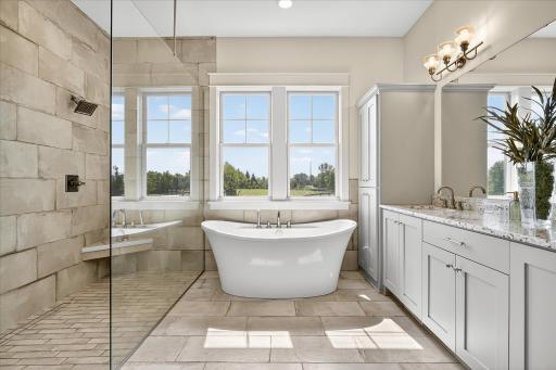 Spa-like retreat with a freestanding soaking tub, dual-sink vanity, and oversized walk-in shower.