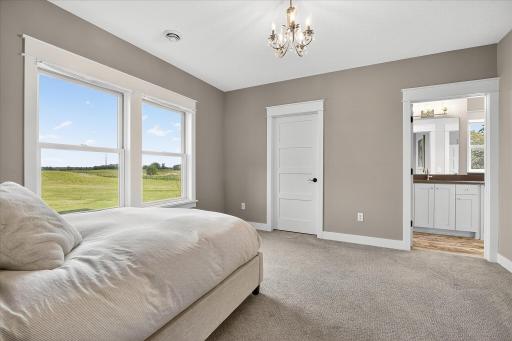 Comfortable secondary bedroom with plush carpeting, large windows, and neutral tones. Also has a Jack- and Jill full bathroom.