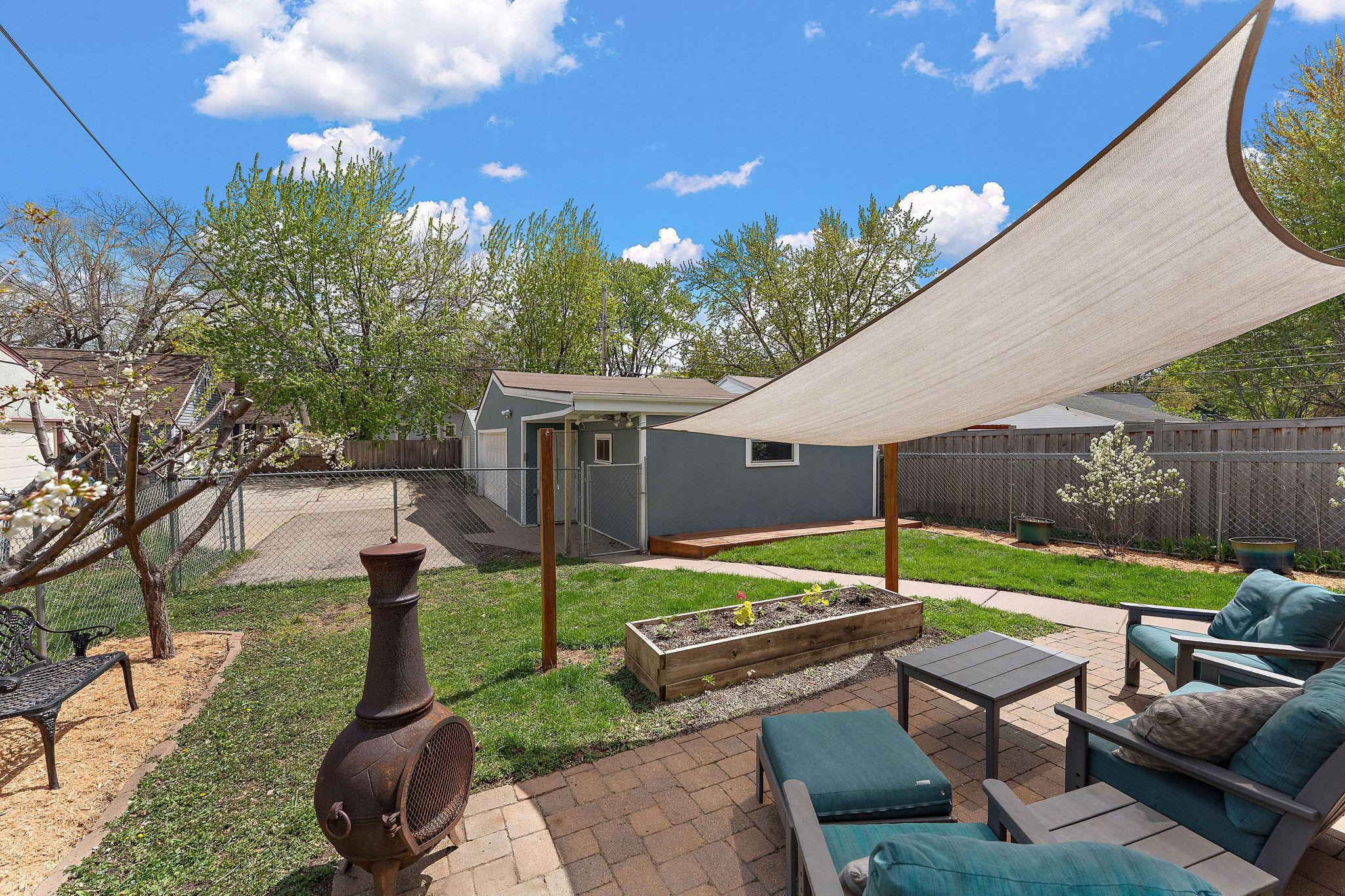 Paver patio in back. Plum trees pictured on the left.