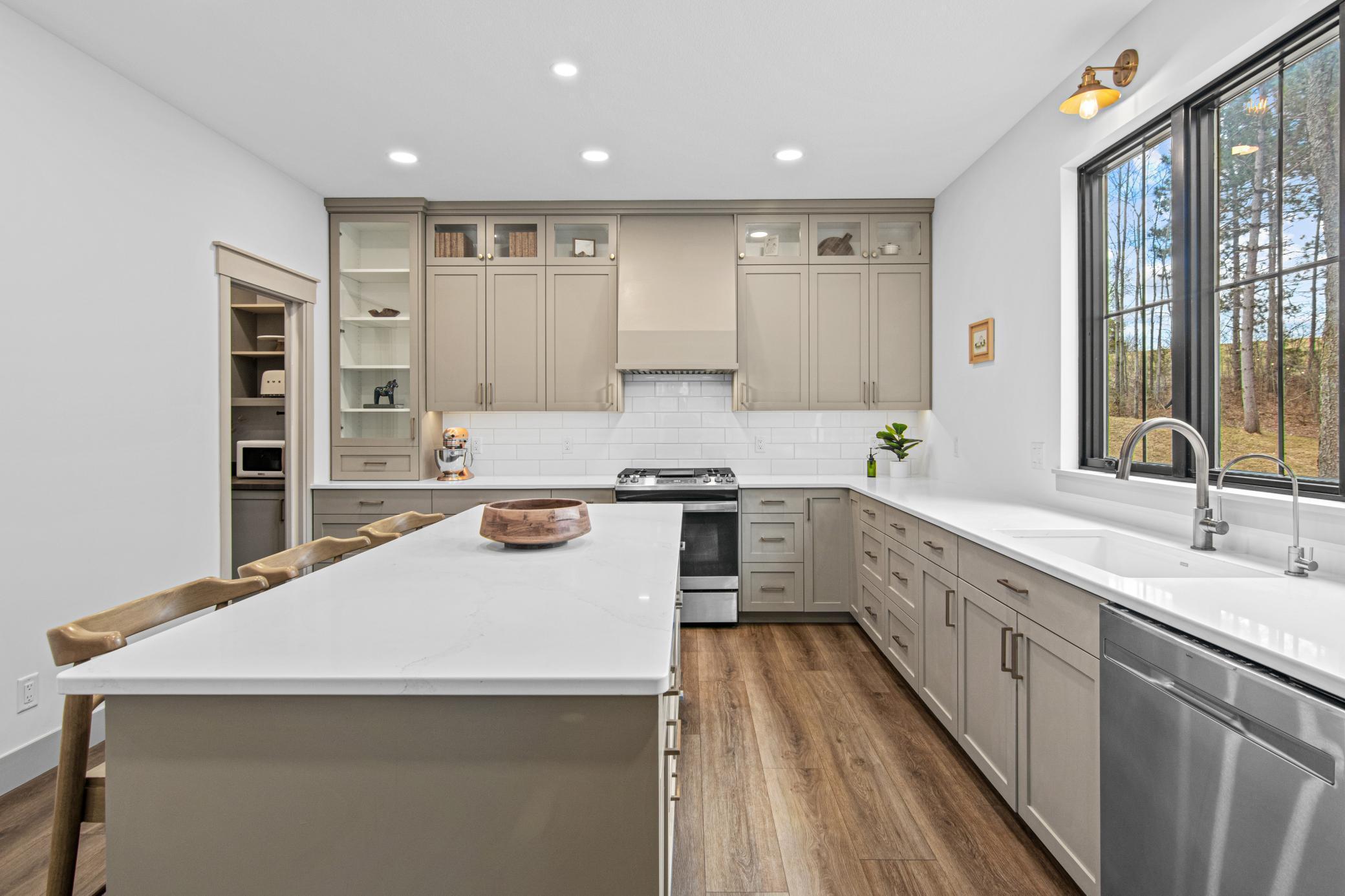 Gorgeous kitchen featuring quartz countertops, large center island, and walk-in pantry