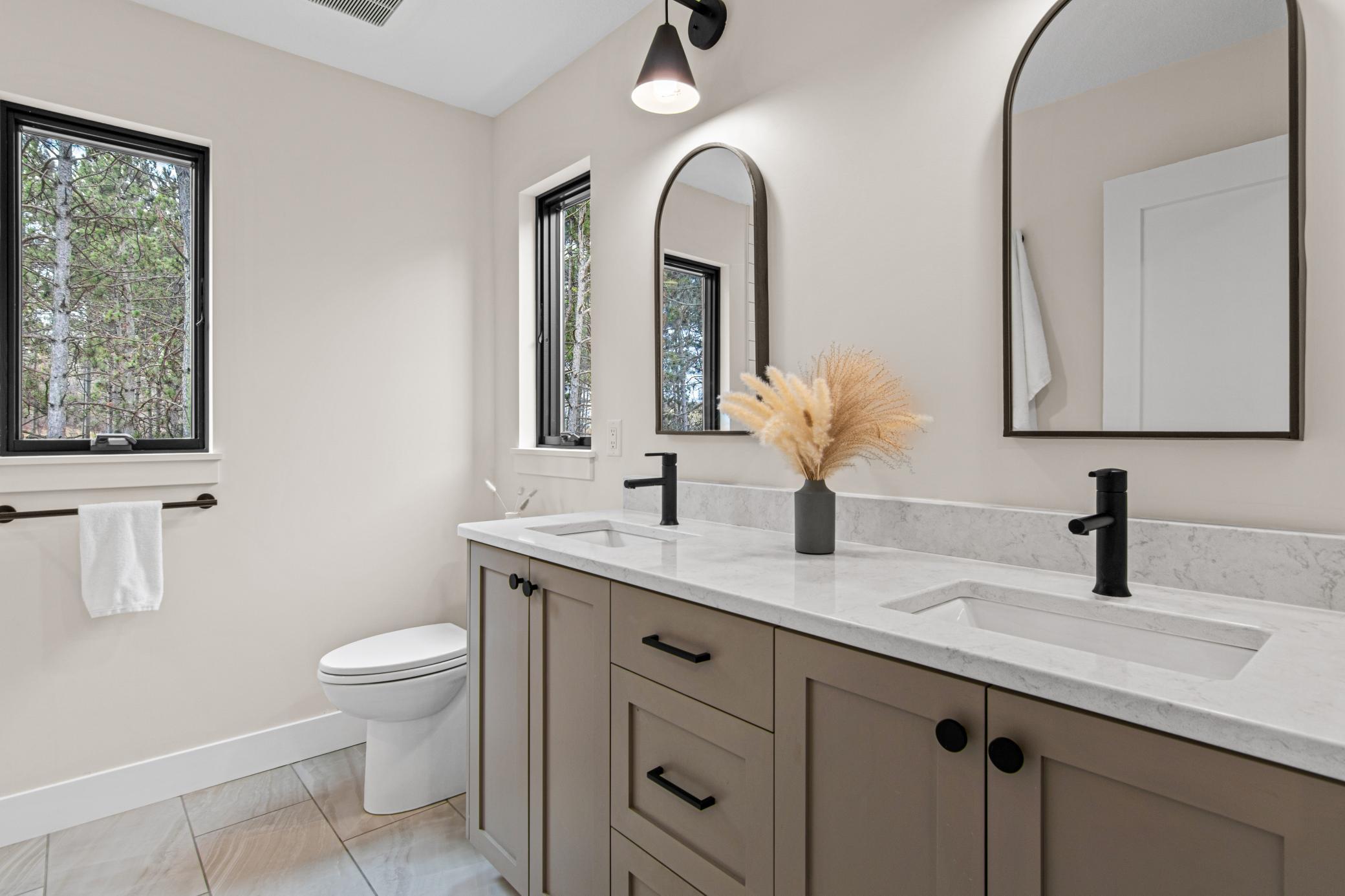 En-suite primary bathroom with quartz countertops, double vanity, and modern finishes
