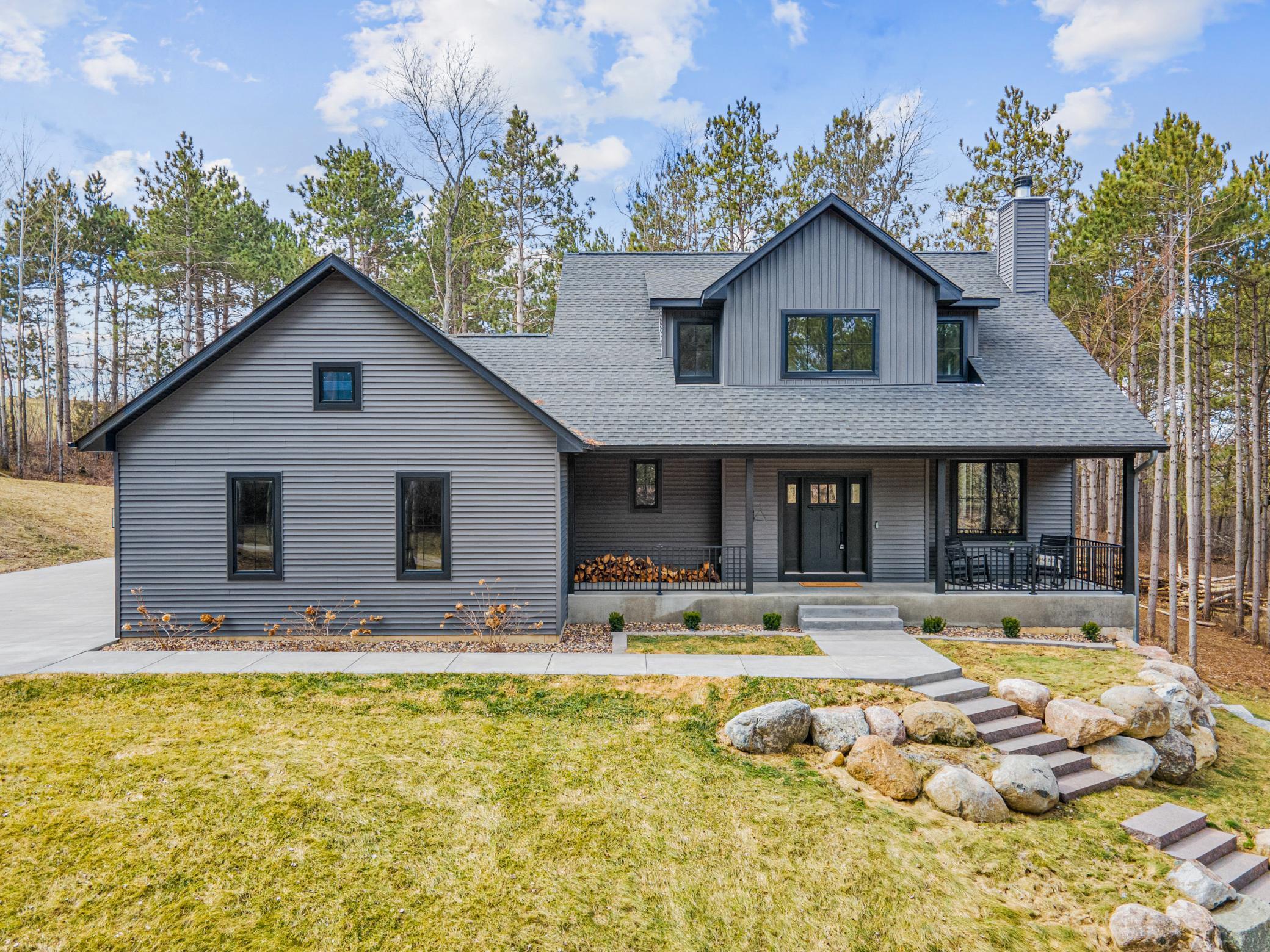 Striking exterior with natural landscaping and a welcoming covered front porch
