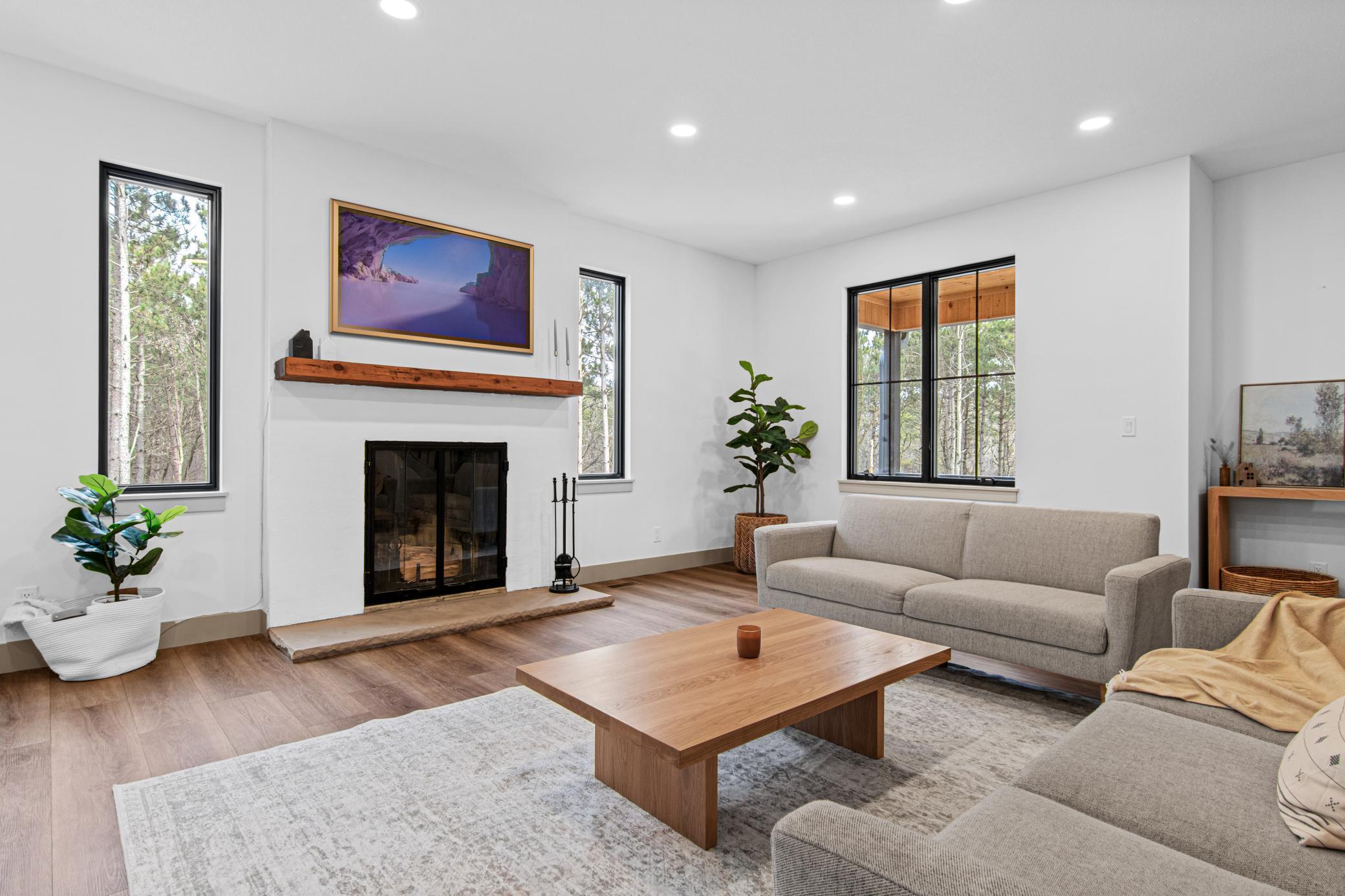 Light-filled living room with wood-burning fireplace and expansive windows