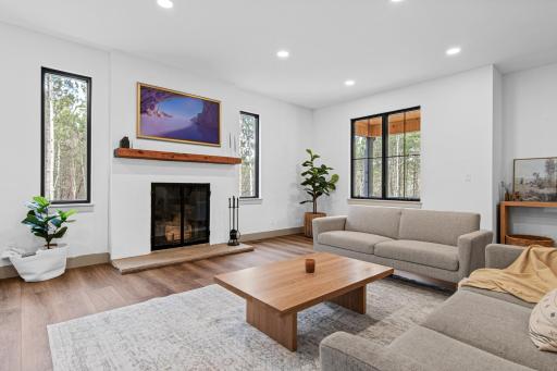 Light-filled living room with wood-burning fireplace and expansive windows