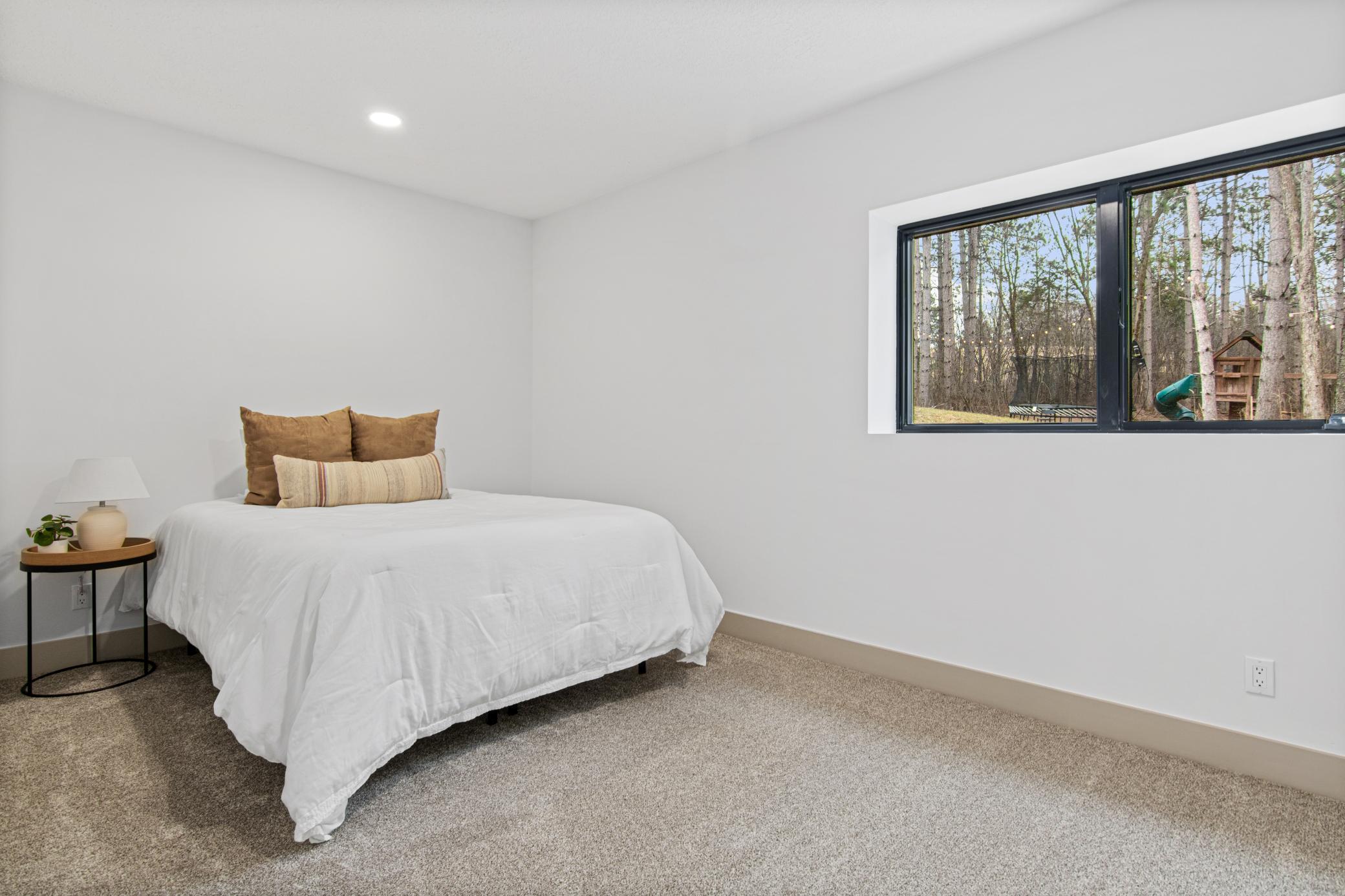 Spacious lower level bedroom 5 with views of the surrounding landscape