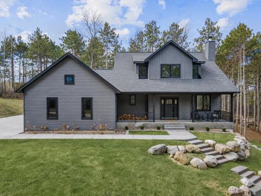 Striking exterior with natural landscaping and a welcoming covered front porch