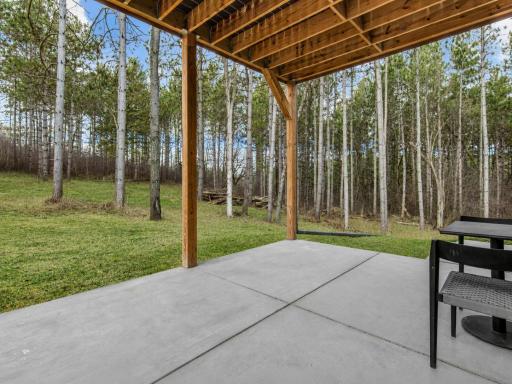 Covered patio offering shaded outdoor space with peaceful wooded views