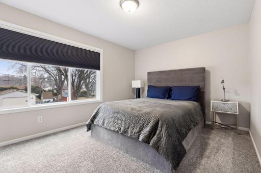 One of three upper level bedrooms. The primary suite offers a private full bath, walk-in closet and custom top/down - bottom/up room darkening pleated blinds.
