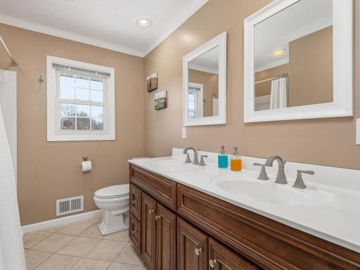 Main level bathroom features a double vanity and tiled floors