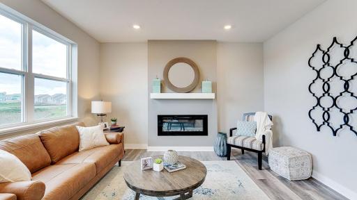 Take note of the large windows and wonderful, electric fireplace! *Photo is of a model home, colors may vary in actual home.