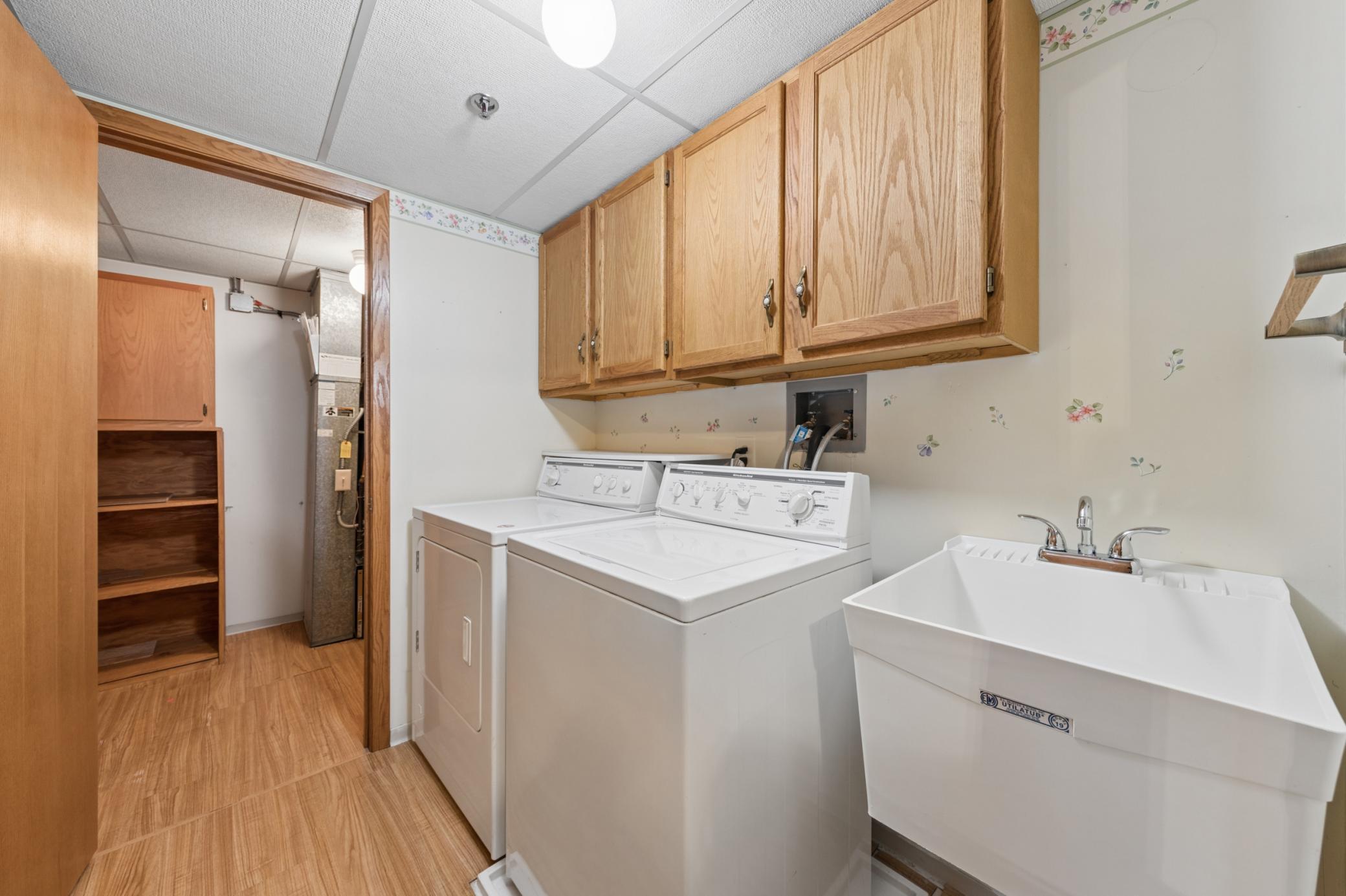Enjoy the convenience of an in-unit laundry room equipped with a utility sink and extra storage cabinets.