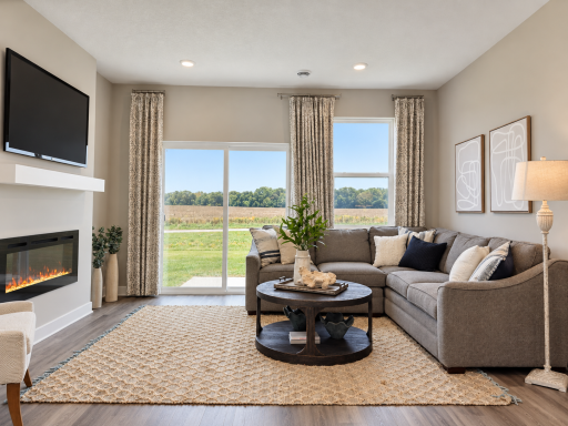 Unwind by the cozy electric fireplace in this bright and welcoming living room.