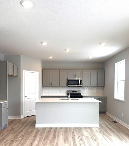 Photo of actual home. LVP flooring, stainless steel Whirlpool appliances, subway tile backsplash, and quartz countertops!