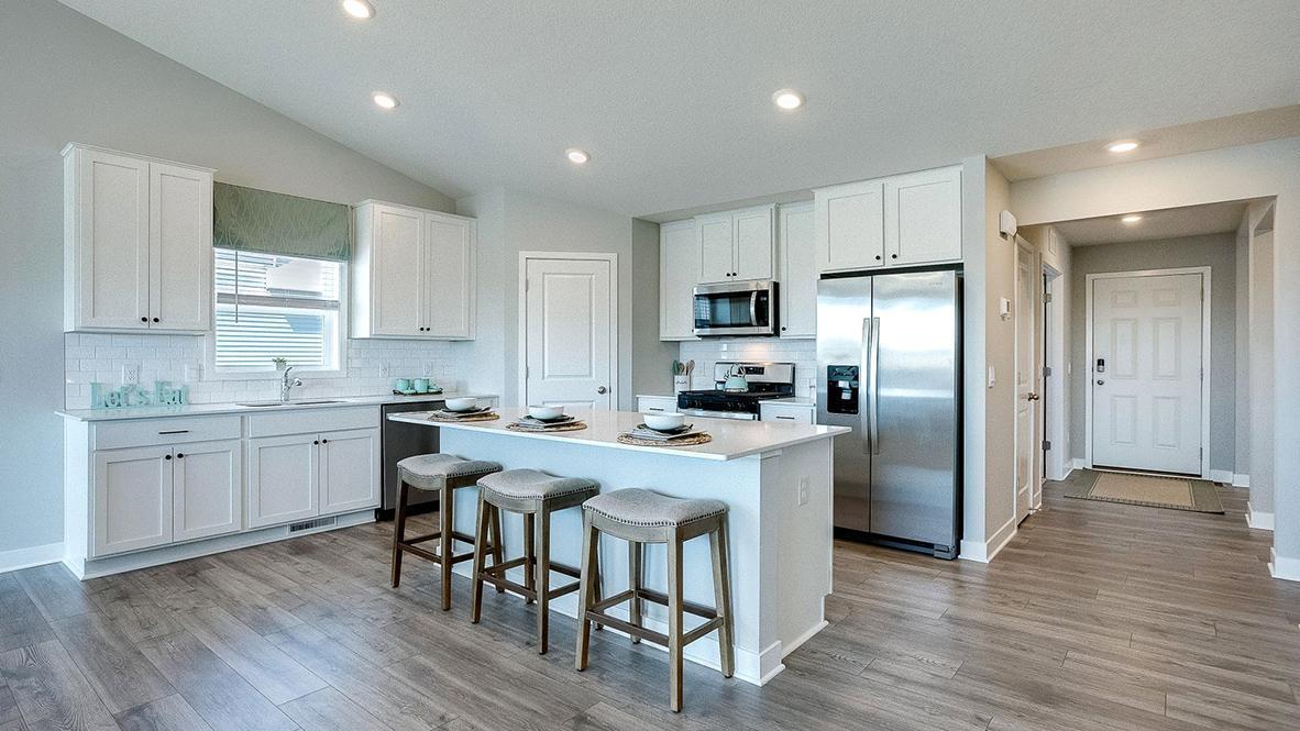 The Finnegan's open concept main level features a spacious kitchen with center island. Photos of model home. Colors and options may vary. Ask Sales Agent for details.