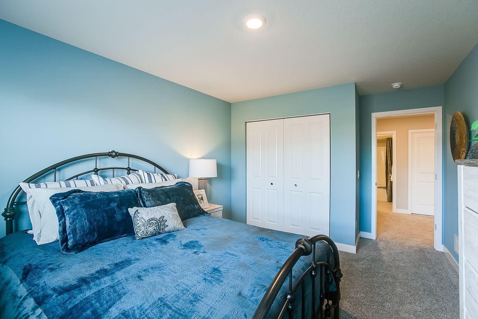 Tucked down in the lower level, and away from the hustle and bustle of the main level living spaces, this bedroom resides adjacent to a full bath and serves as the perfect guest room or your home office! Photo is of model home.