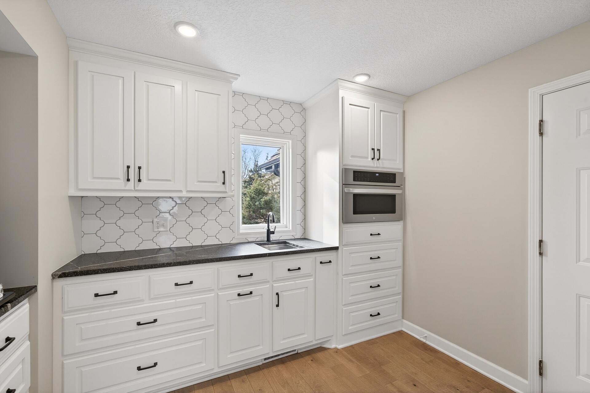 The ultimate butler’s pantry, featuring a prep sink, microwave, and expansive counter space.