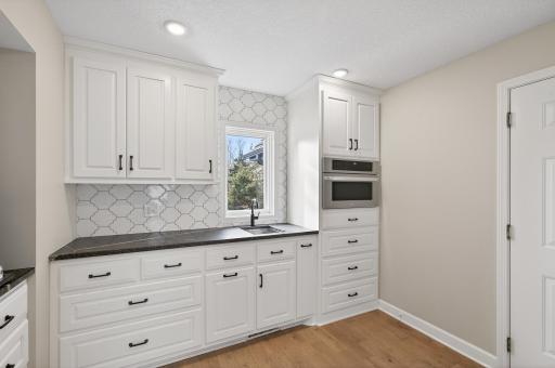 The ultimate butlerâs pantry, featuring a prep sink, microwave, and expansive counter space.