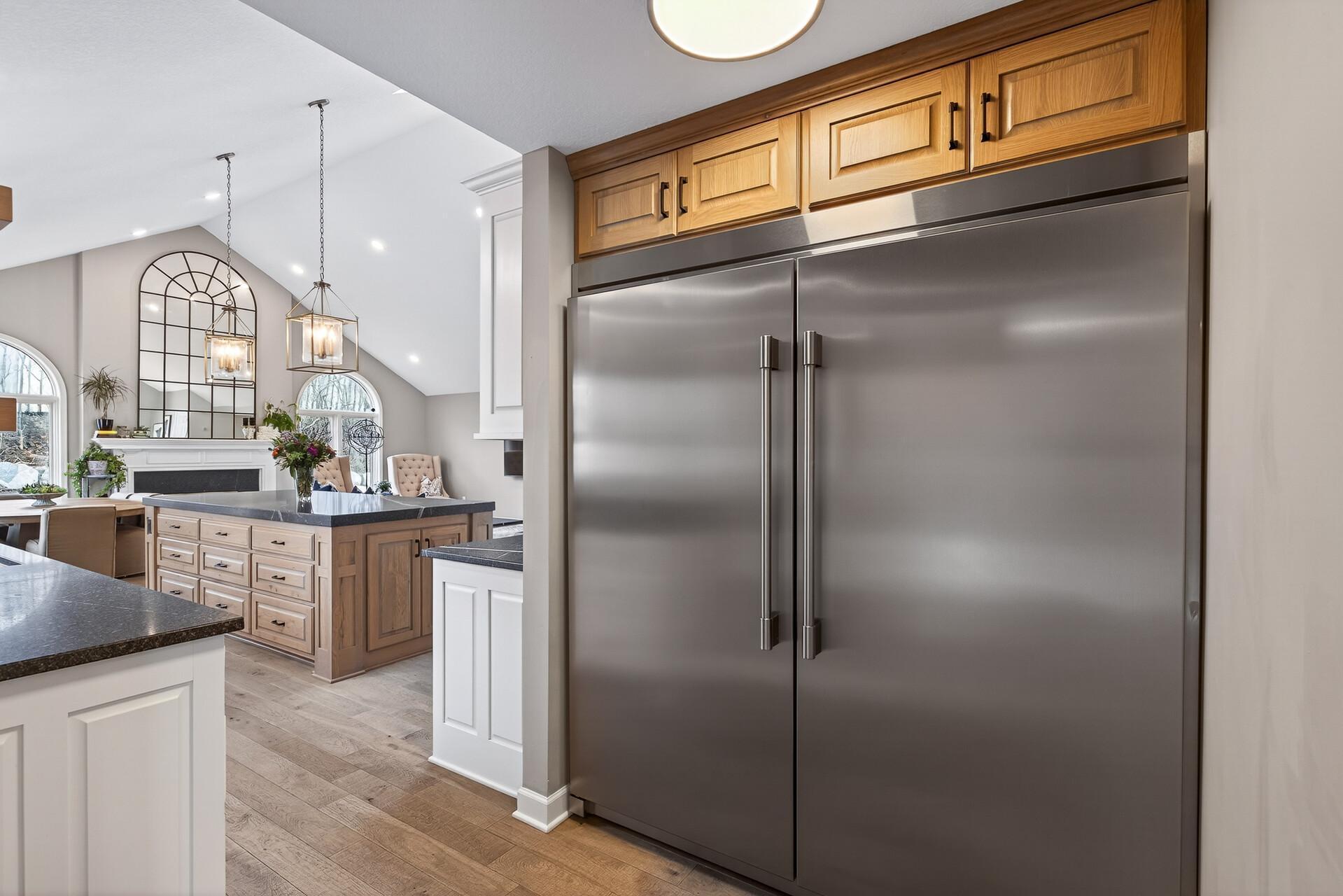 A professional-grade, side-by-side refrigerator and freezer placed between kitchen and butler’s pantry.