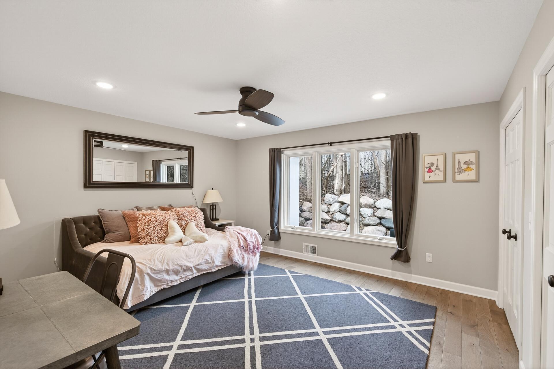 From the continuous plank floors to the expansive yard views, every detail in this bedroom reflects the home's cohesive design.