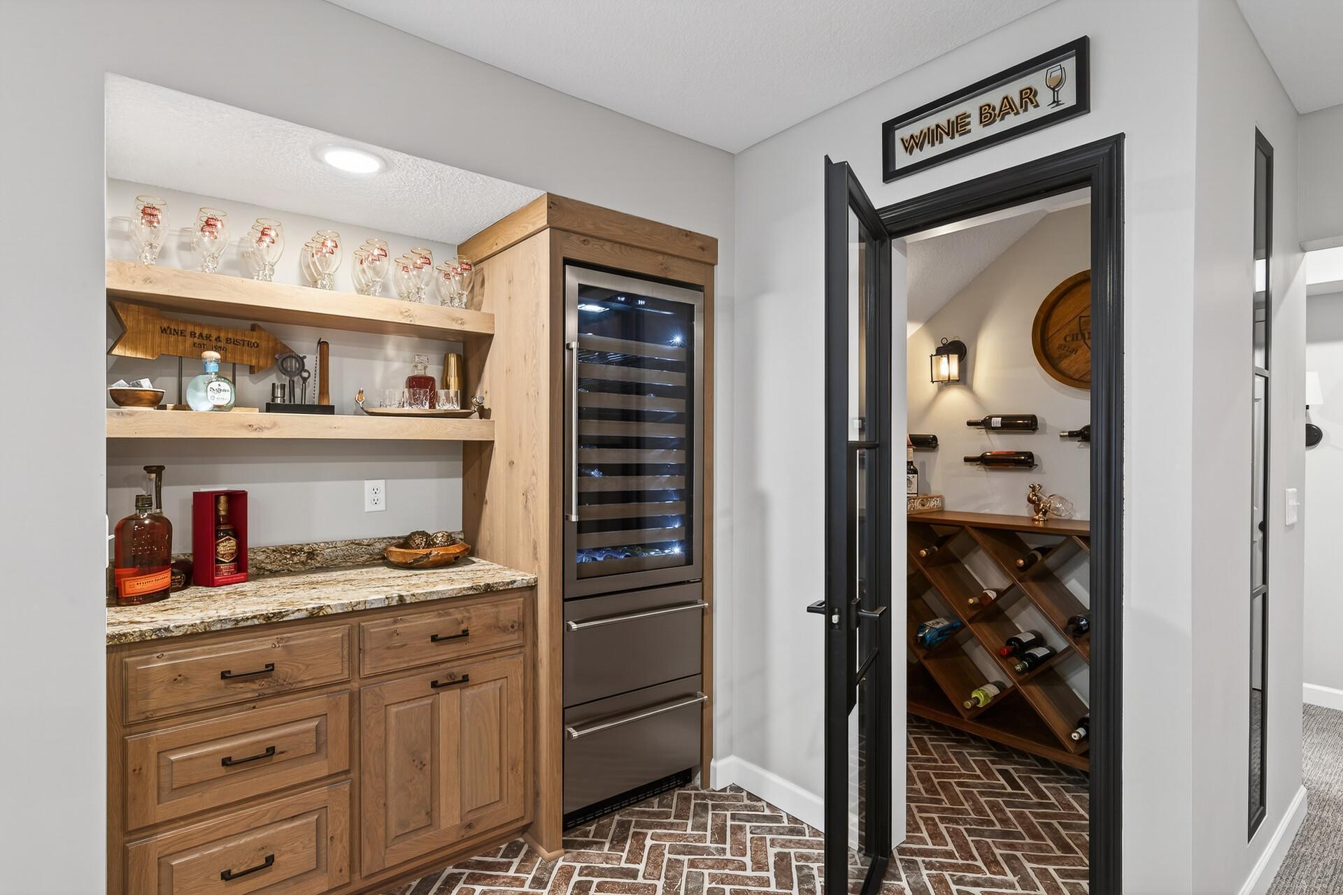 Beverage bar features a built-in cooler and a direct entrance to the private wine cellar.