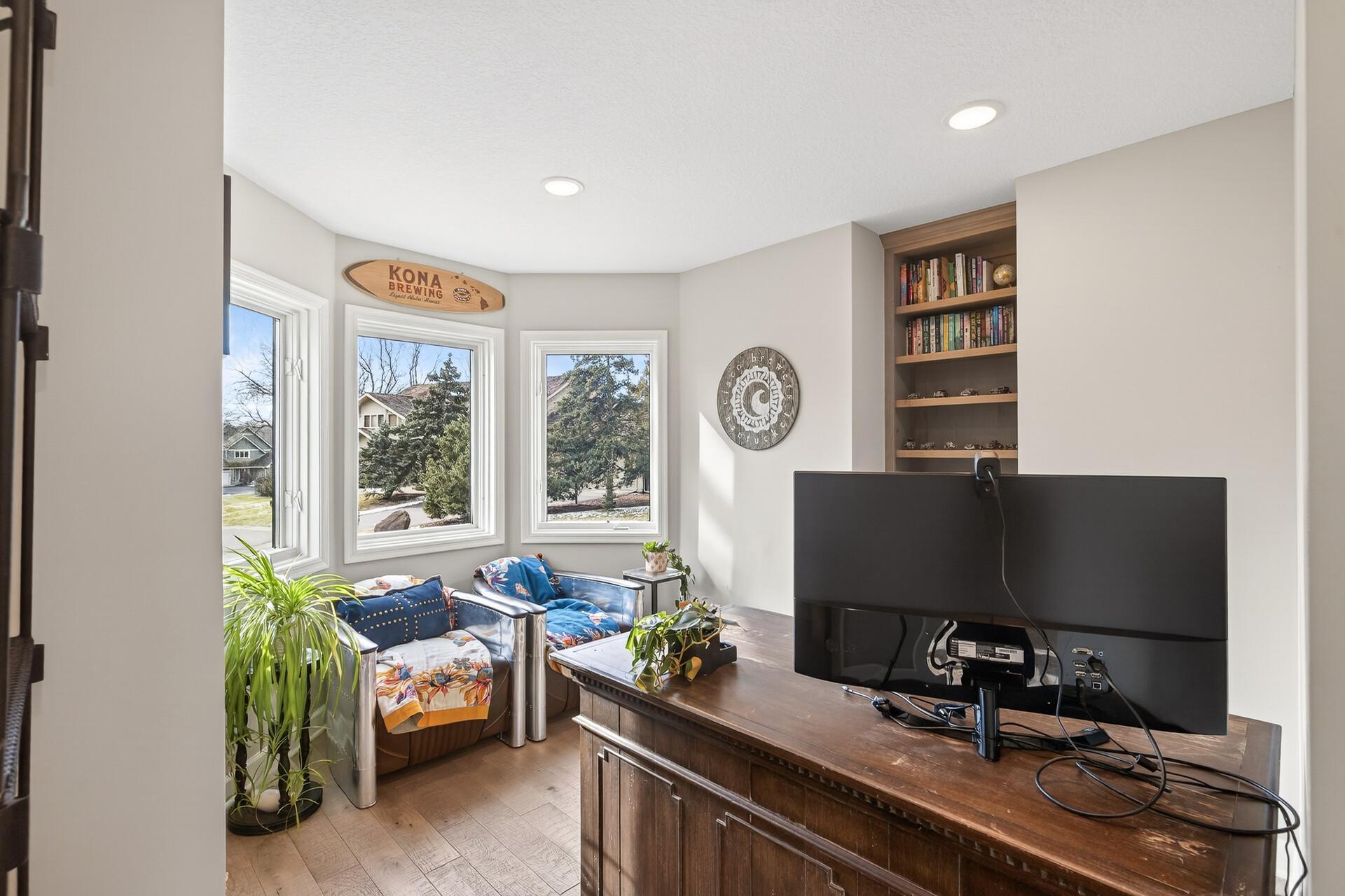 A bright, private home office sits just off the main entrance, featuring sweeping views of the front yard.
