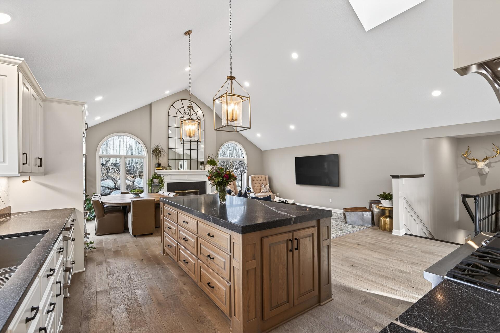 A versatile center island anchors this seamless space, bringing together the kitchen, living, and dining room with wide-plank real hardwood flooring flowing throughout the entire main level of the home.