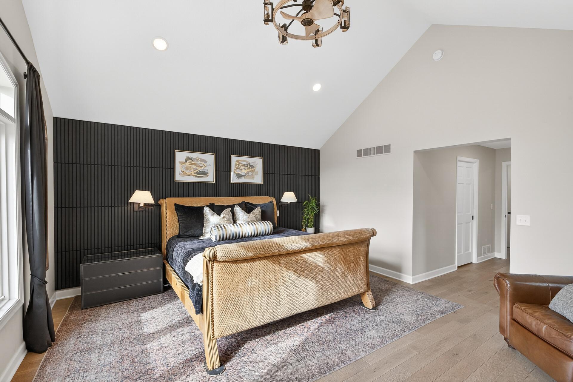 A dramatic dark-toned accent wall adds a bold, contemporary edge to the light-filled primary suite.