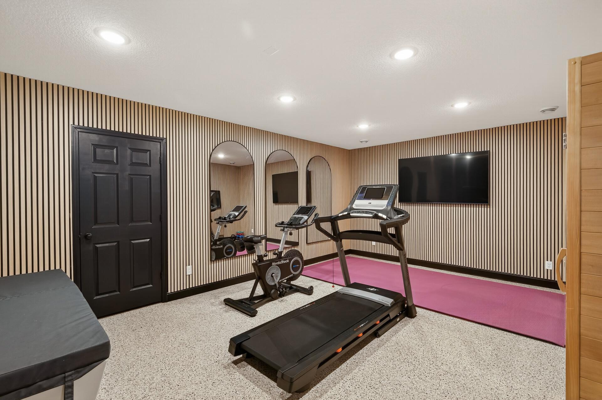The home gym mirrors the home's architectural elegance with arched mirrors.