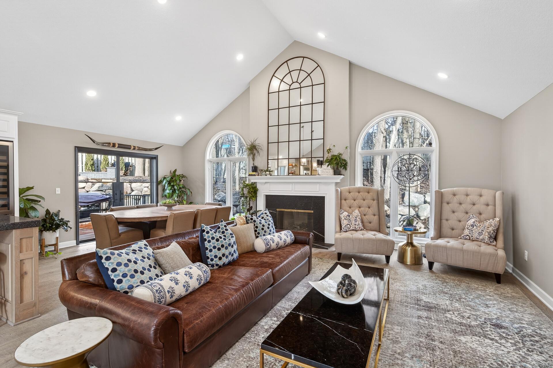 The home features a fireplace centered between dramatic arched windows, creating a stately and bright atmosphere for entertaining.