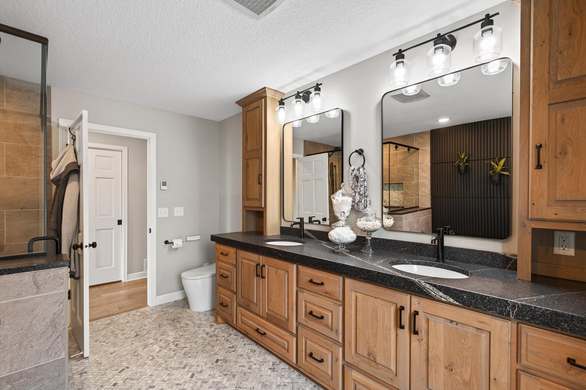 Clean lines and expansive custom cabinetry define this dual-vanity retreat, offering a place for everything in style.