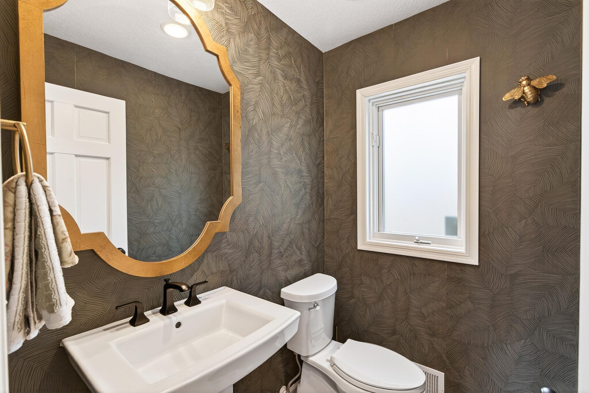 A powder room is privately tucked away between the butler’s pantry and the mudroom.