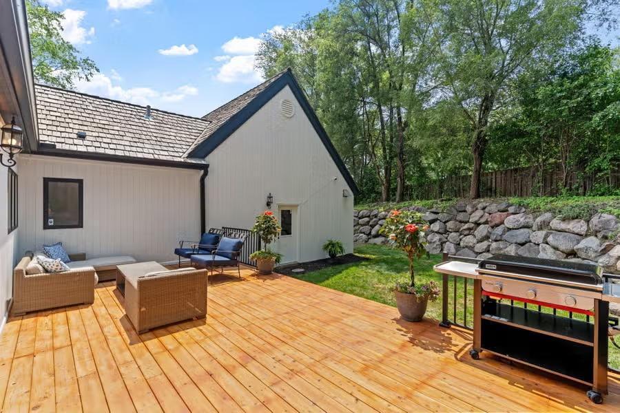The massive boulder wall creates distinct levels in this private, fenced-in yard, framed by mature trees for added seclusion.