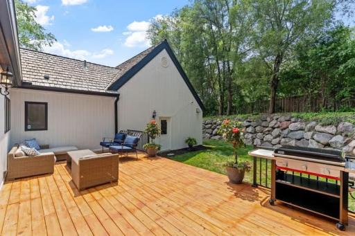 The massive boulder wall creates distinct levels in this private, fenced-in yard, framed by mature trees for added seclusion.