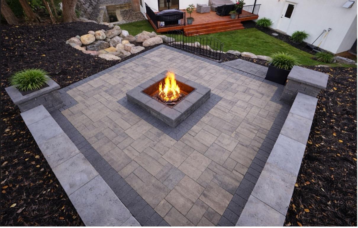 A custom fire pit with built-in seating offers a perfect gathering spot outside.