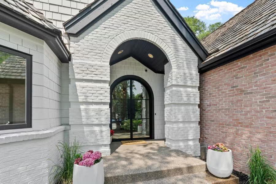 The texture of the aggregate sidewalk and stairs complements the timeless brick exterior.