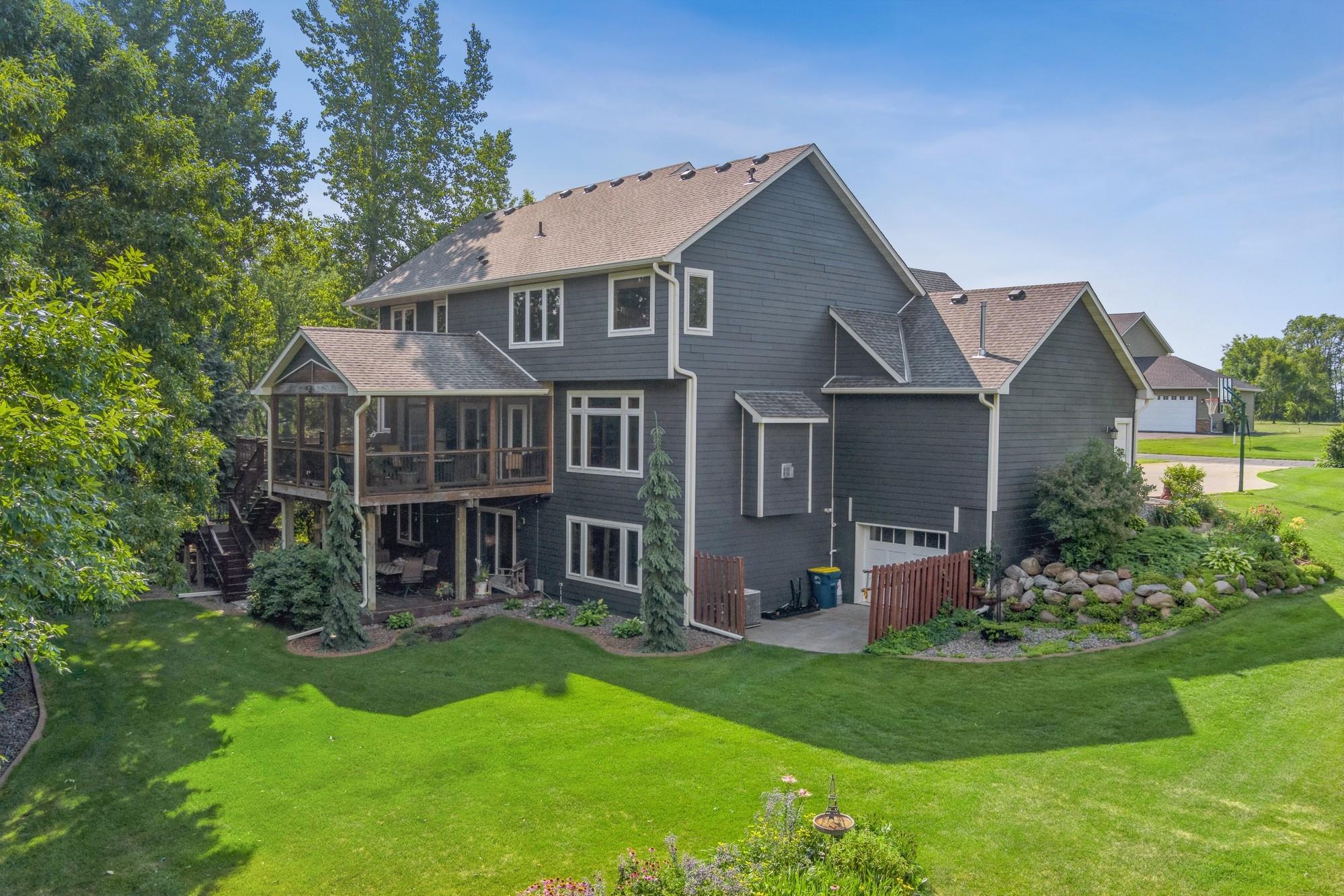 Inviting three-season porch that flows seamlessly to the patio, offering a wonderful setting for morning coffee, evening relaxation, and effortless indoor-outdoor living.