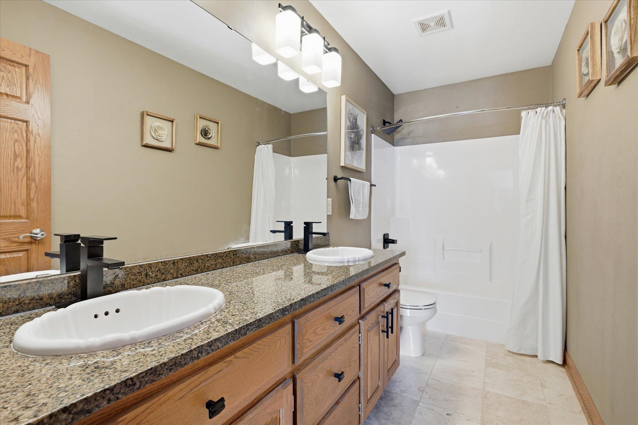 Upper-level full bath featuring double sinks, offering added convenience and space for busy mornings.