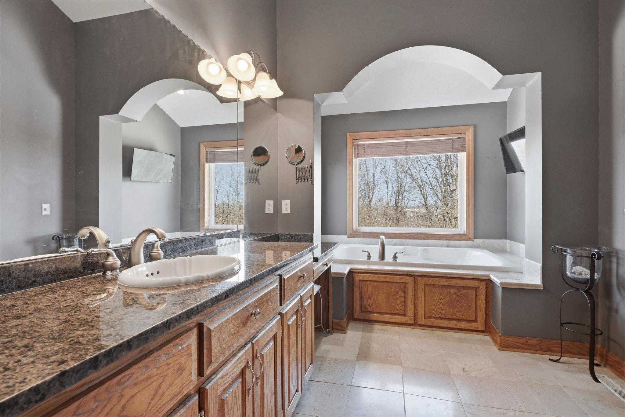 Elegant primary bathroom with granite surfaces, heated tile flooring, and quality craftsmanship throughout.