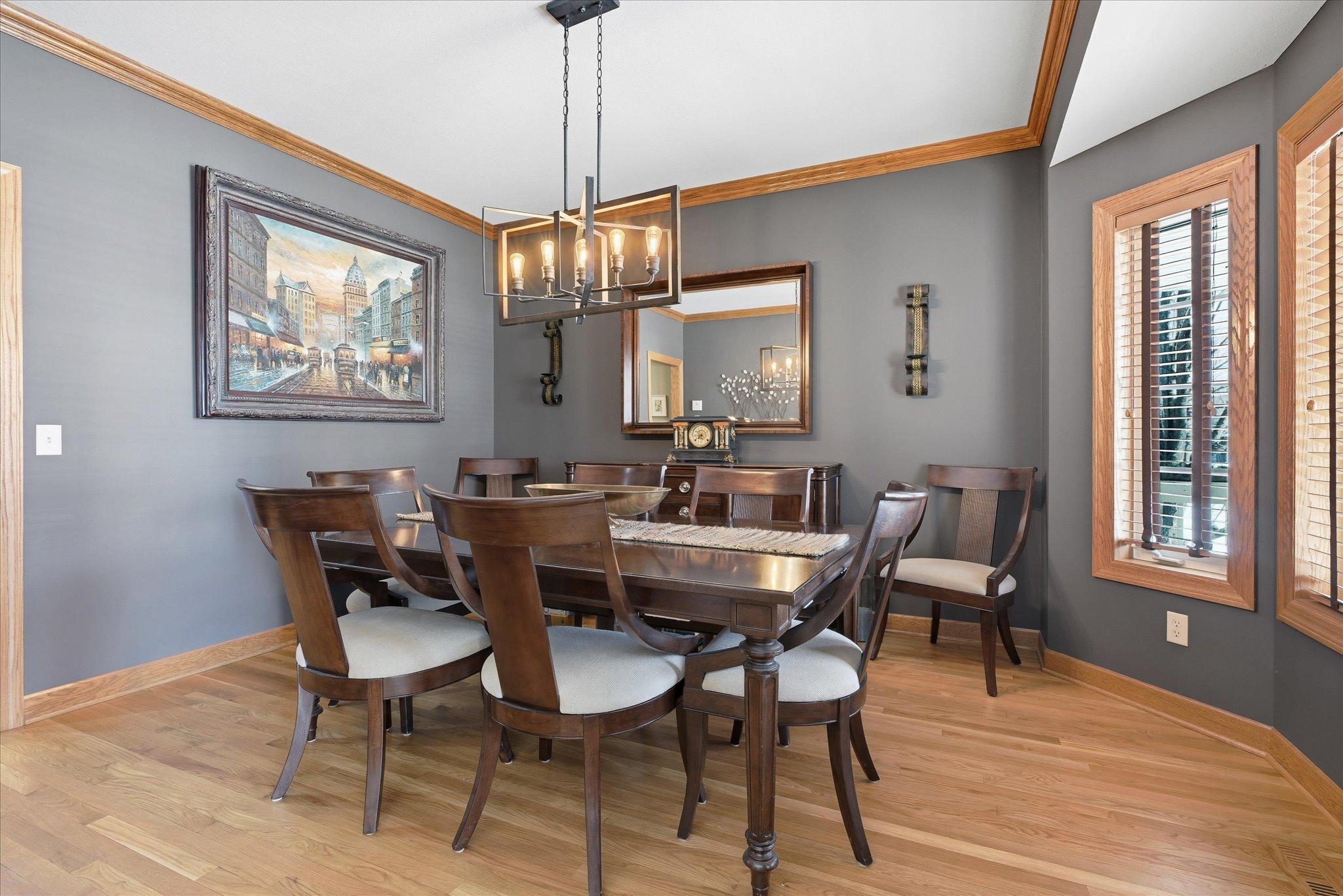 Formal dining room highlighted by a new light fixture, creating a warm and inviting space perfect for hosting dinners and special gatherings.