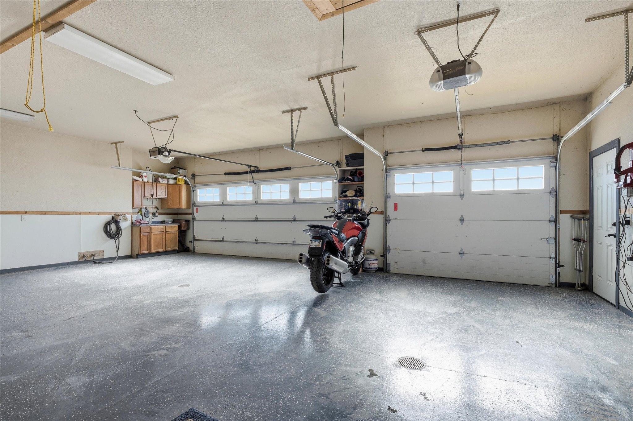 Hot and cold water spigots add practical functionality, making this space perfect for vehicles, hobbies, and workshop use.