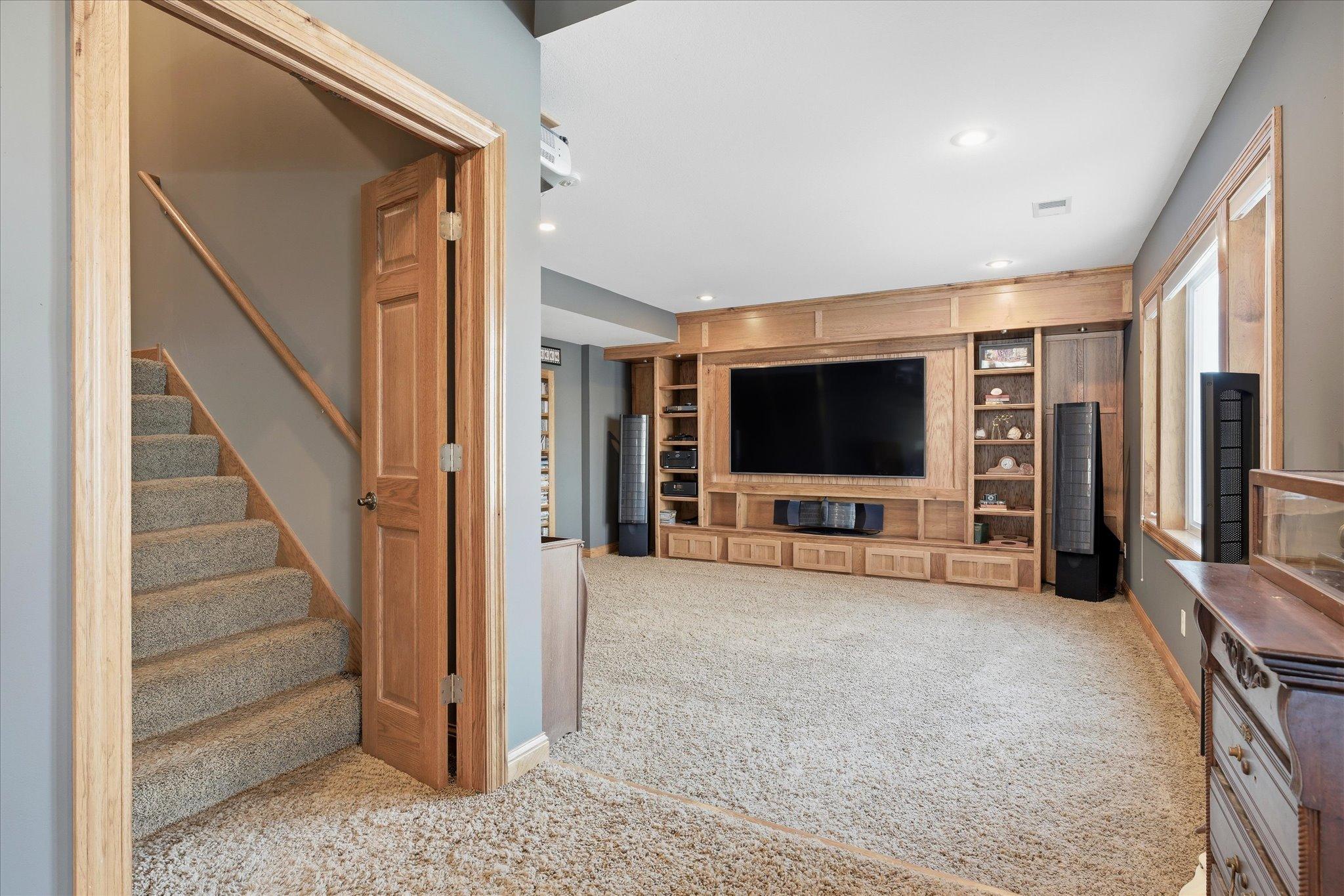 Unique lower-level media/theater room offering a cozy and dedicated entertainment space ideal for enjoying movies and media.