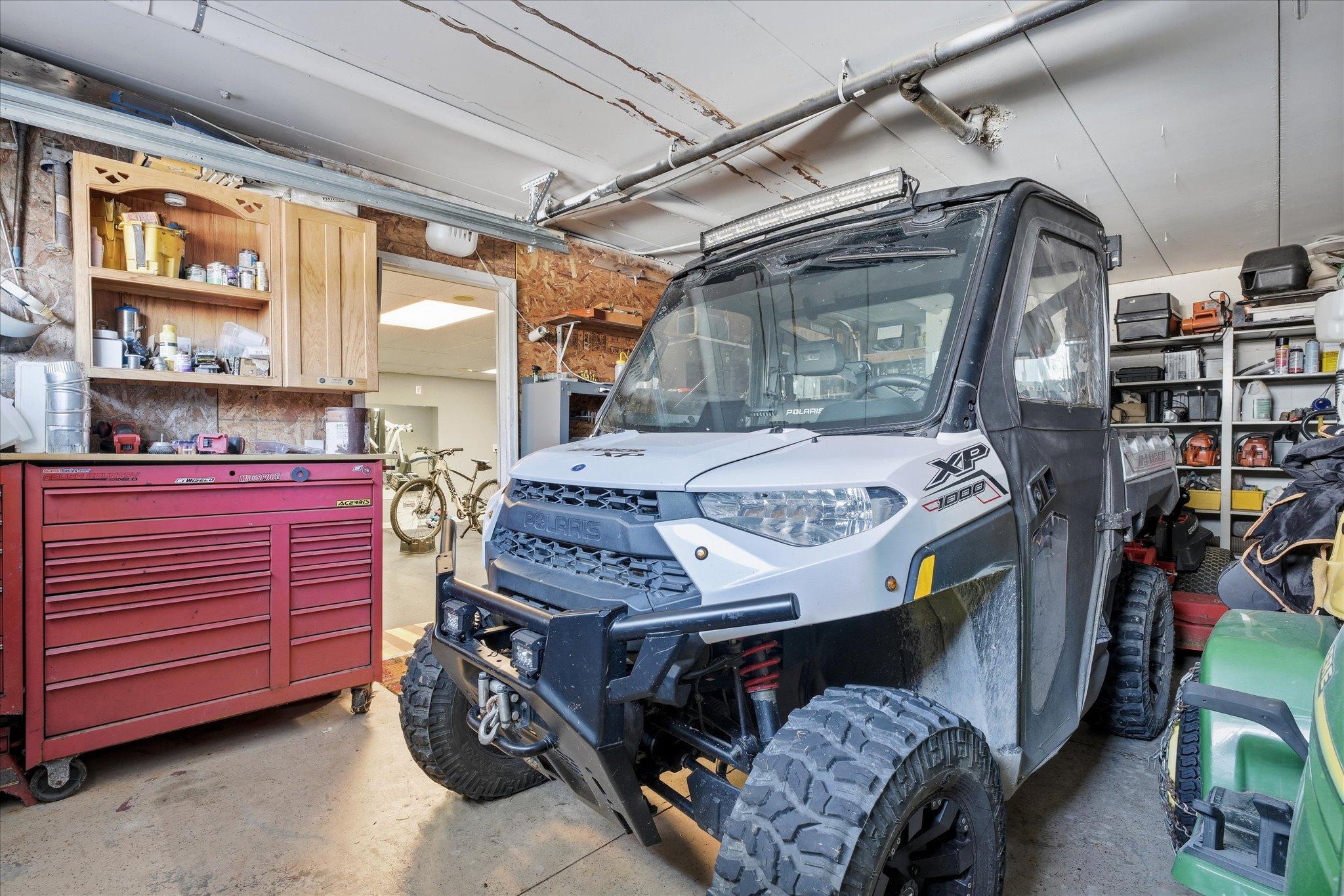 Large tuck-under garage providing excellent space for vehicles, recreational equipment, and workshop projects, with easy access to the home’s lower level.