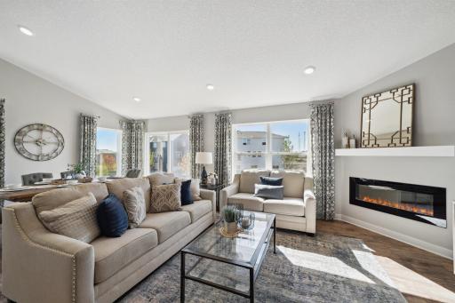Family room includes electric fireplace with mantel and extended flooring.