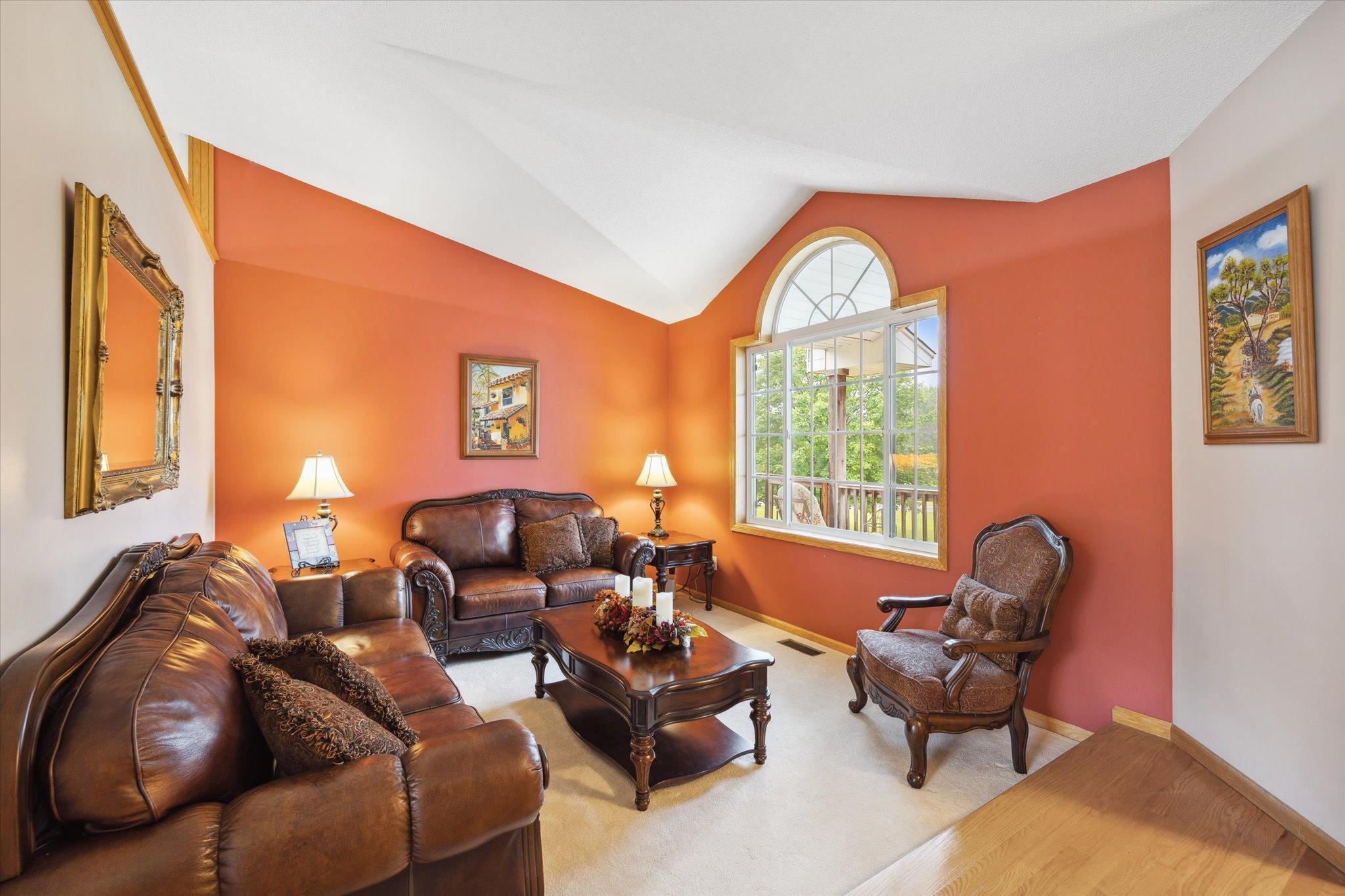 Additional main-level living area features vaulted ceilings, a large arched window, and flexible use as a sitting room or secondary gathering space.