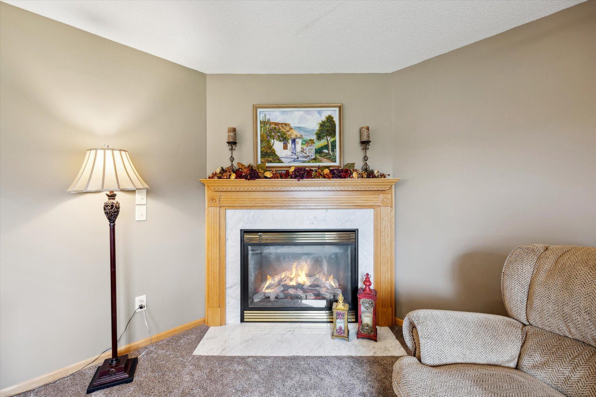Main living room features a gas fireplace, natural light, and comfortable gathering space.