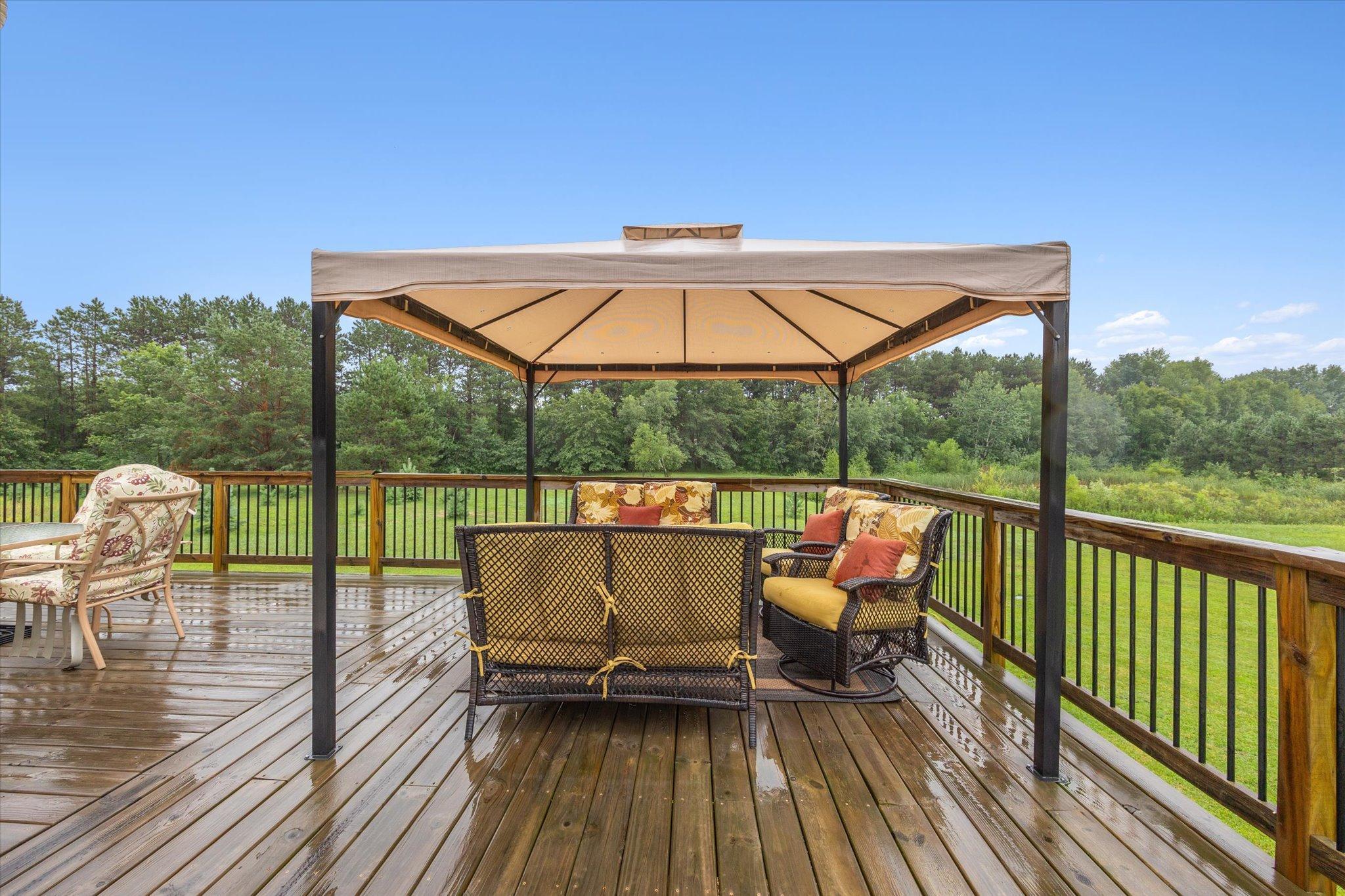 Covered section of the deck creates an additional outdoor seating area with views of the surrounding acreage.