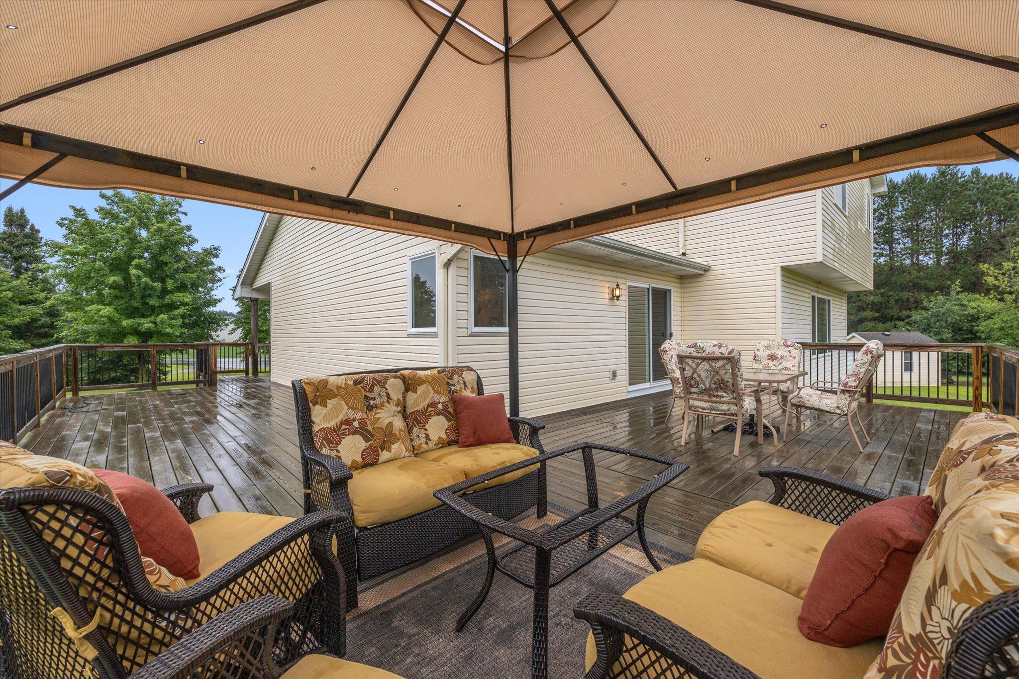 Covered outdoor seating area on the deck provides a comfortable place to enjoy the surrounding natural setting.