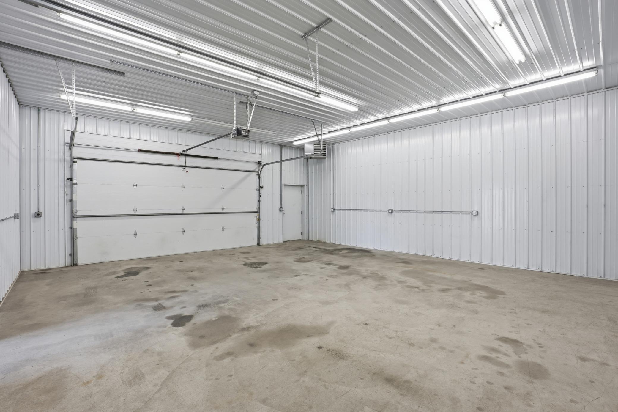 Finished insulated garage bay offers clean, bright enclosed space for workshop, storage, or specialty vehicle use.